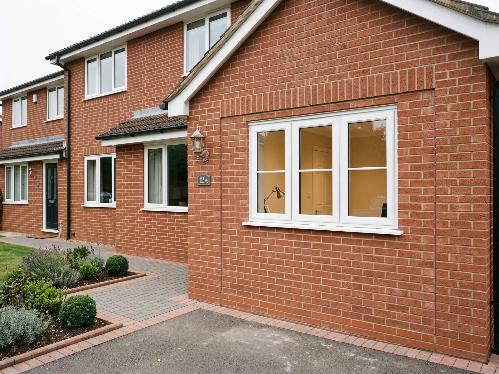 A brick house where the garage door opening has been closed with matching brickwork and a new window fitted, by LD&C Homes