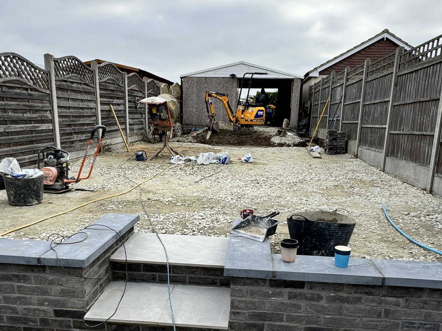 The garden under construction, with the raised porcelain patio and brick retaining wall laid and the upper level being excavated, by LD&C Homes