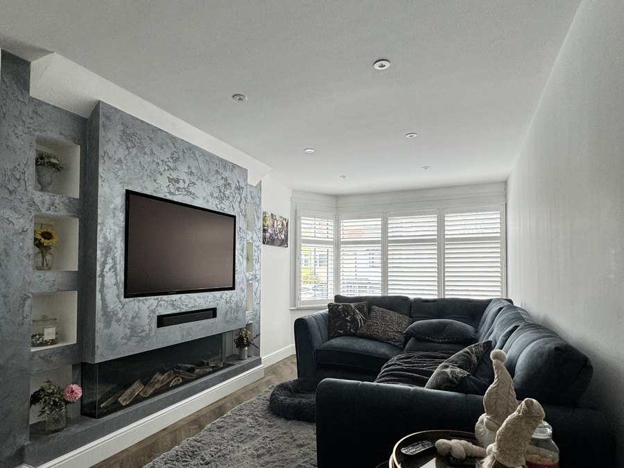 The finished lounge with the polished plaster media wall, inset fire and shuttered bay window, by LD&C Homes