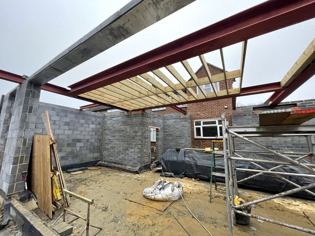 The steel frame installed over the ground floor, carrying the new floor structure above with timber joists between the beams, by LD&C Homes